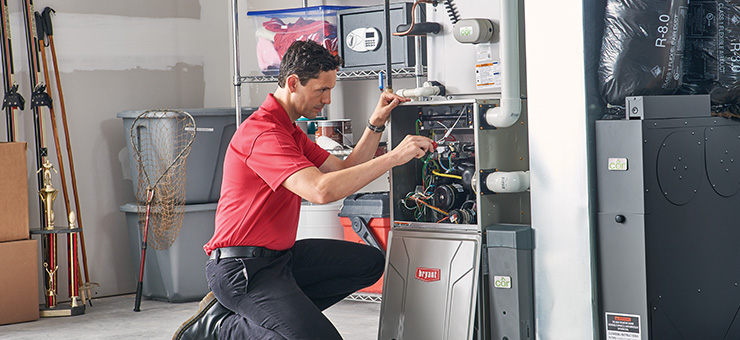 HVAC technician doing routine furnace maintenance